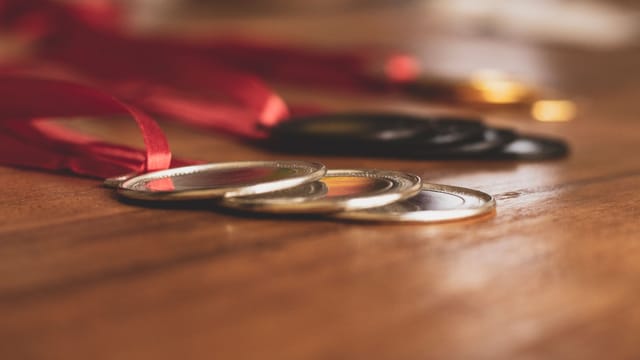 Close-up view of medals on a wooden table, showcasing bronze, silver, and gold awards.