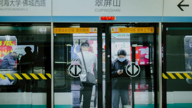 Commuters at Cuipingshan metro station in China, capturing urban life and public transport dynamics.