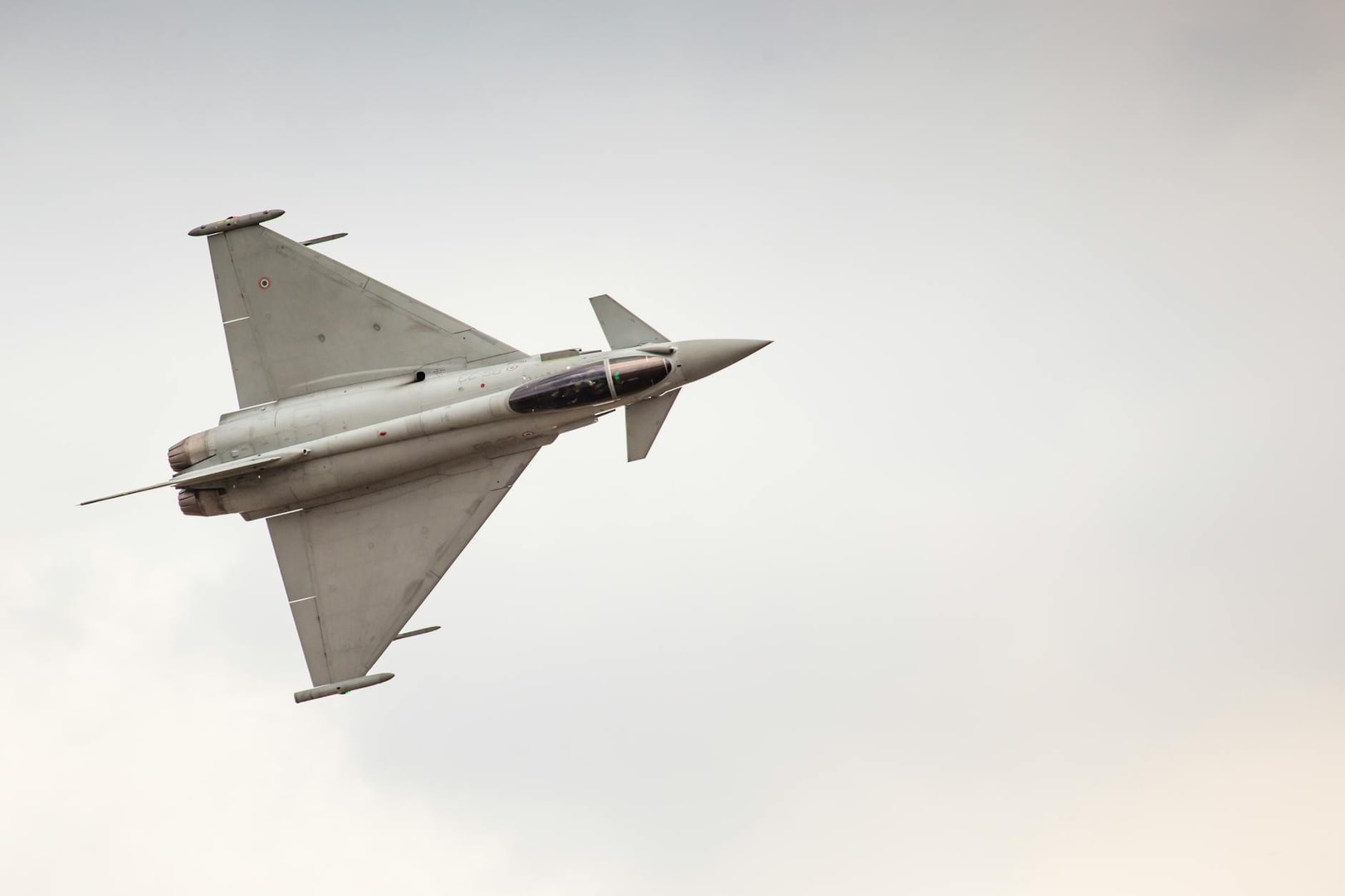 Fighter jet soaring through the sky showcasing agility and speed during an airshow performance.