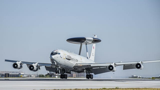 NATO AWACS aircraft preparing for takeoff on sunlit runway, showcasing its advanced surveillance capabilities.