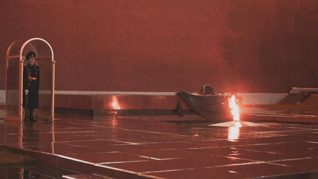 Guard stands beside eternal flame at Moscow's Tomb of the Unknown Soldier.