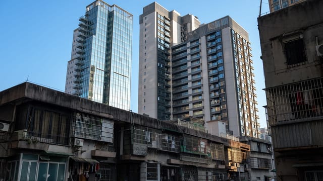 High-rise buildings and older apartments in Guangzhou, China, reflecting urban contrast.