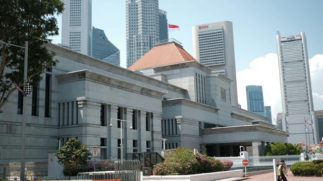 A view of Singapore's urban landscape featuring iconic skyscrapers and a prominent building under a clear sky.
