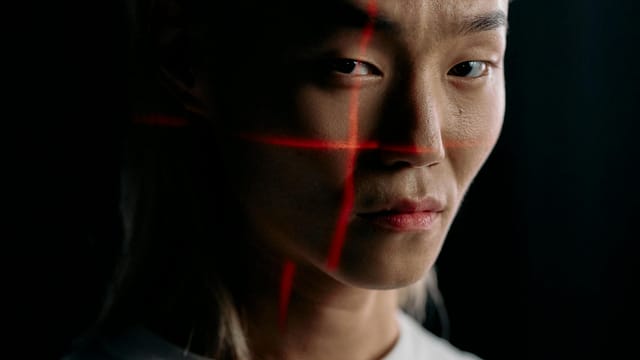 Close-up of an expressive face with facial recognition technology in a studio setting.