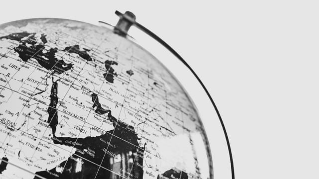 Monochrome photo of a globe focusing on the Middle East region, depicting political boundaries.