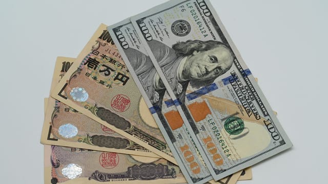 Close-up image of US dollars and Japanese yen notes, representing currency exchange concept.