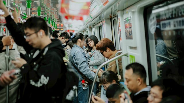 A bustling scene of commuters on a subway in Nanjing, China, showcasing urban daily life.
