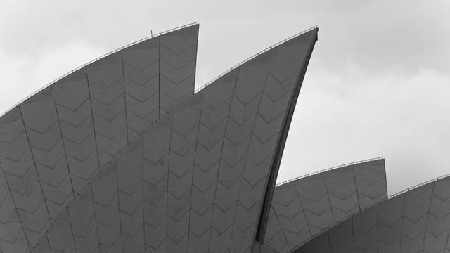 Black and white close-up of the Sydney Opera House's unique architectural sail design.