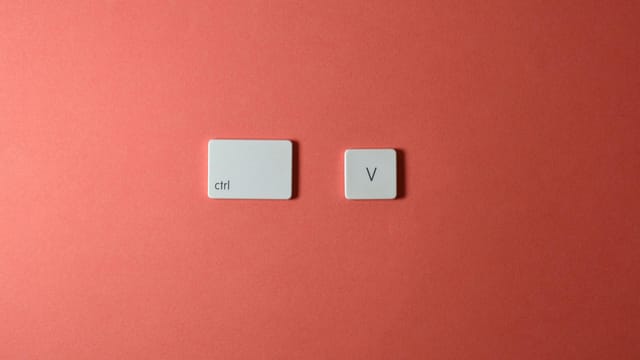 Minimalist composition of Ctrl and V keyboard keys on a coral background, perfect for tech-themed designs.