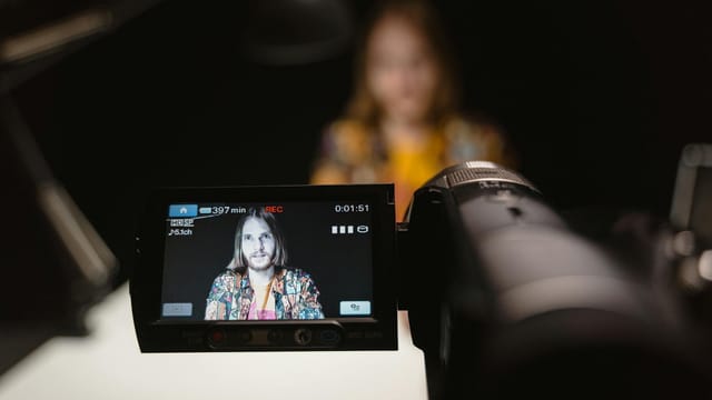 Close-up view of camera capturing a person's portrait in a recording studio.