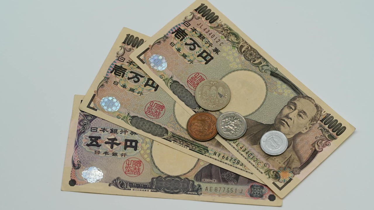 Close-up of Japanese Yen banknotes and coins arranged on a flat surface.