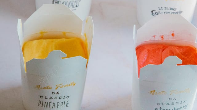 Close-up of fruity ice cream flavors in branded packaging, showcasing pineapple and strawberry varieties.