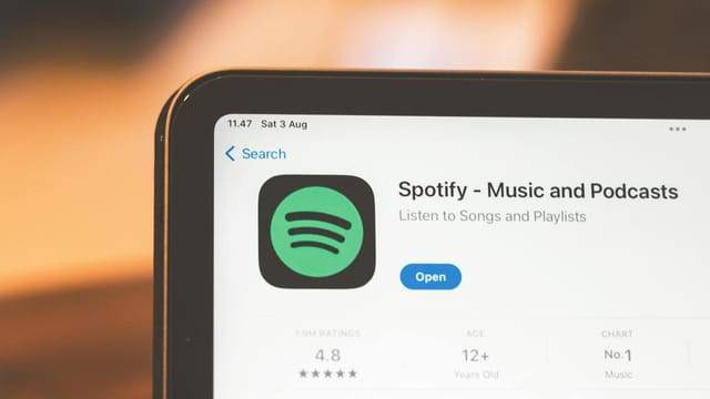 Close-up of Spotify app page displayed on a tablet screen, highlighting its features.