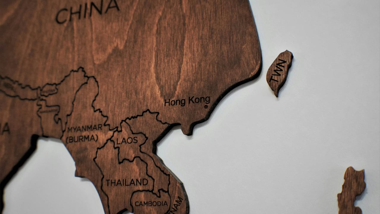 Detailed wooden map art showcasing countries in Asia with carved region names.