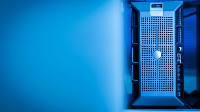 Illustrative image: Close-up of a modern server unit in a blue-lit data center environment.