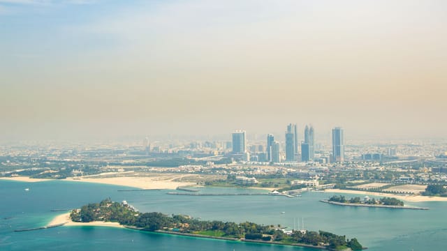 Stunning aerial view of Dubai's skyline with artificial islands and turquoise waters.