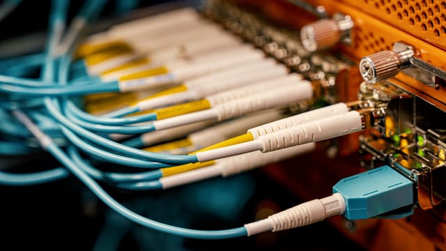 From above of optical switch equipment with many similar connectors with rubber cables and metal parts