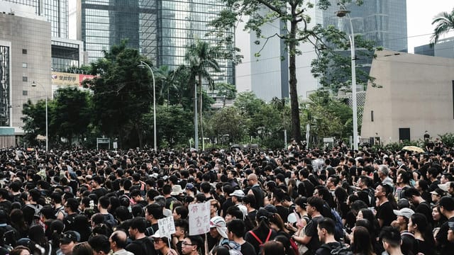 Massive crowd gathers during a protest in Hong Kong's urban district, showcasing urban activism.