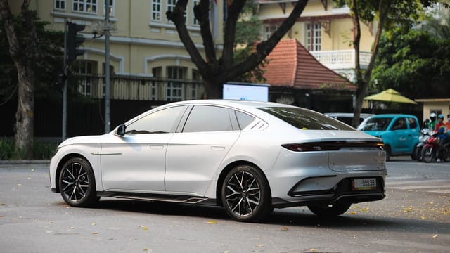 Sleek white electric car parked on a city street with classic buildings in the background.