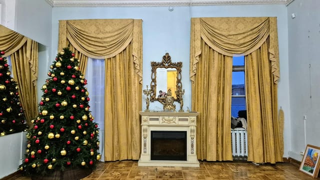 Luxurious vintage interior with a decorated Christmas tree and ornate fireplace.