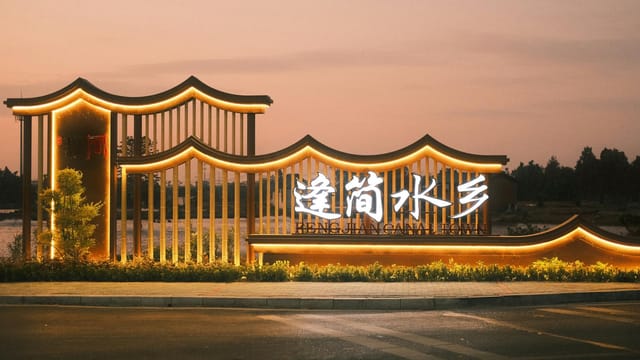 Beautifully illuminated architectural sign at sunset with warm lighting and scenic background.
