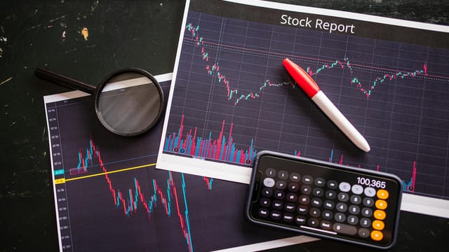 Stock report with charts, calculator, and magnifying glass for financial analysis.