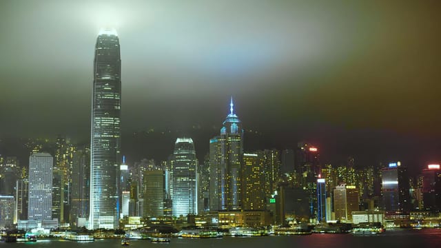 Dramatic view of Hong Kong's skyline at night featuring iconic illuminated skyscrapers.