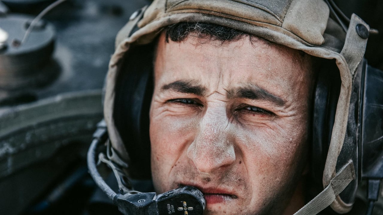 Intense close-up of a soldier wearing a military helmet and communication headset, focused and serious.