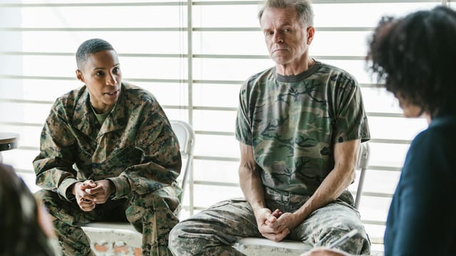 Military personnel discuss mental health in a supportive group therapy session.