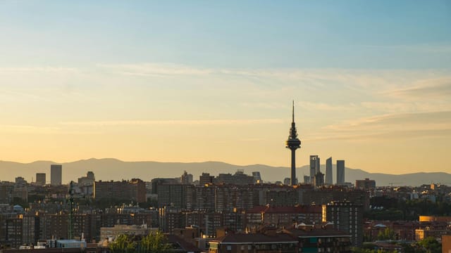 A beautiful sunset over Madrid's skyline featuring Torre España and urban architecture.