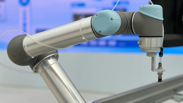 Detailed close-up of a modern industrial robotic arm in a manufacturing setting.