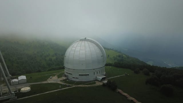 Aerial view of BTA-6 observatory amidst fog, located in Zelenchuksky District, Russia.