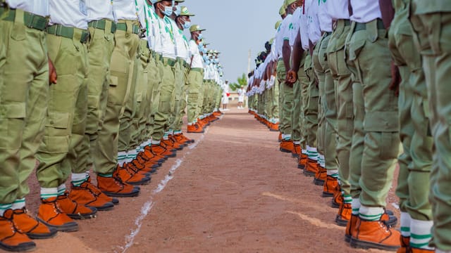 A group of uniformed personnel standing in formation outdoors, showcasing discipline and unity.