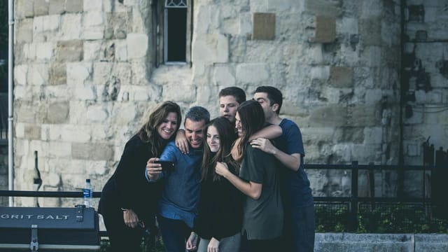 Group of friends enjoying a moment together while taking a selfie outdoors.