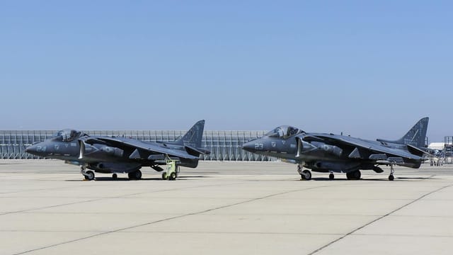 Fighter jets on the tarmac at March Air Reserve Base in California under a clear sky.