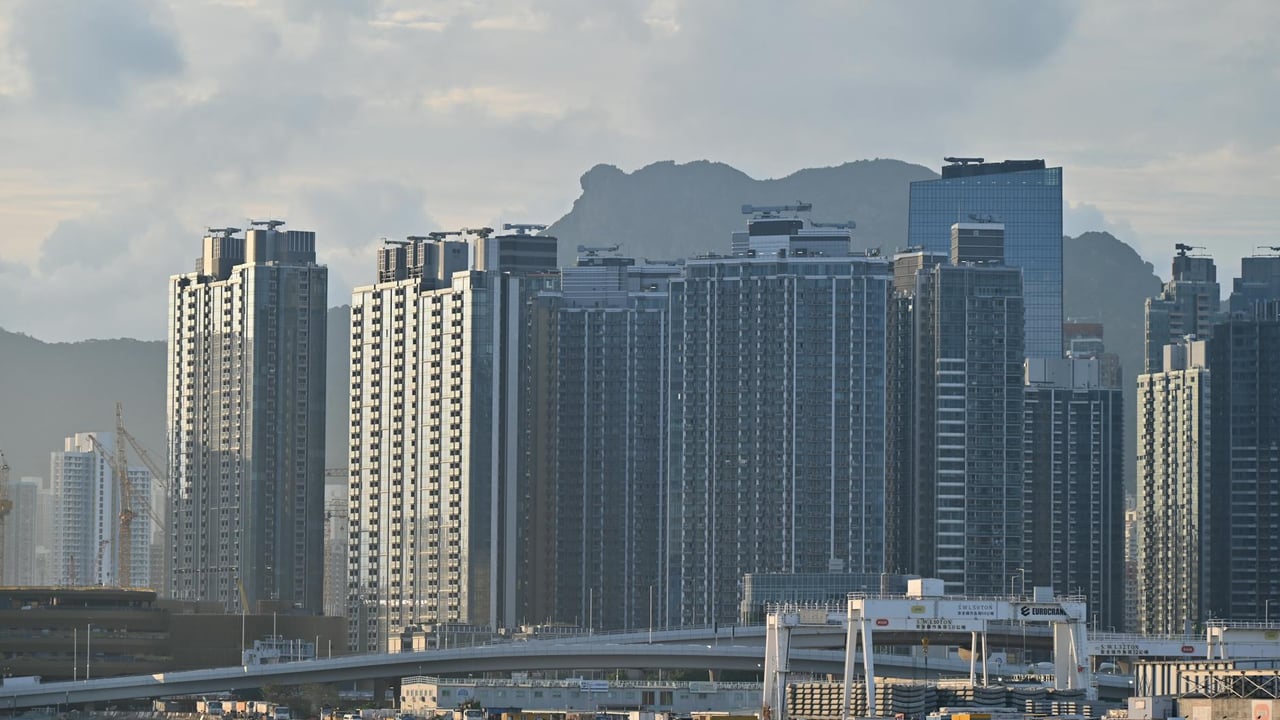 Cityscape featuring towering high-rise buildings against a mountainous backdrop.