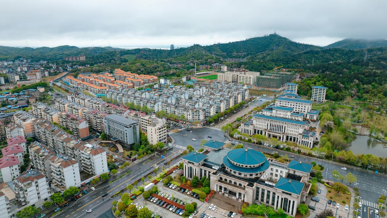 Aerial view of Jiu Jiang Shi showing urban architecture and scenic greenery in Jiang Xi Sheng, China.