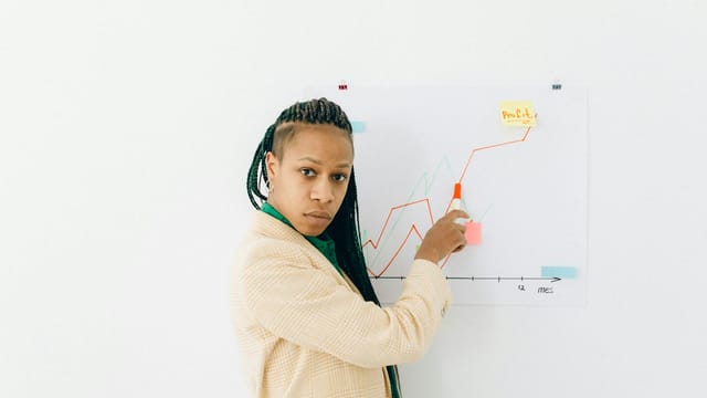 Confident woman explains financial data and growth strategy in a presentation.