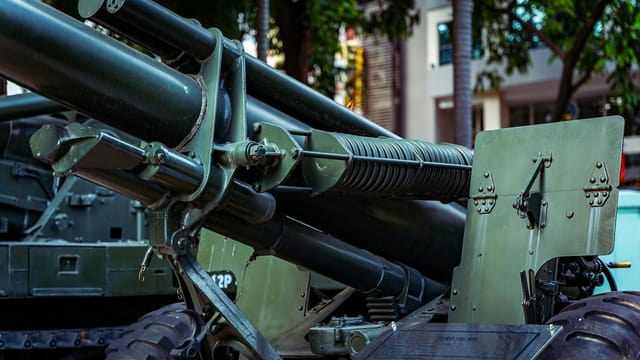 Detailed view of military artillery equipment displayed outdoors in a museum setting.