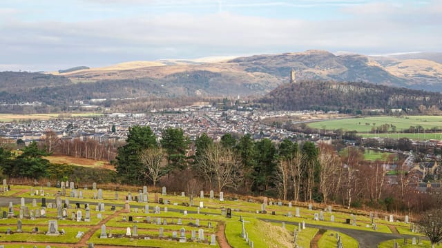 A picturesque view of Wallace Monument in Stirling, Scotland from a local cemetery.