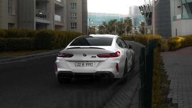 Luxury white BMW M8 car on a city street in Erbil, Iraq.