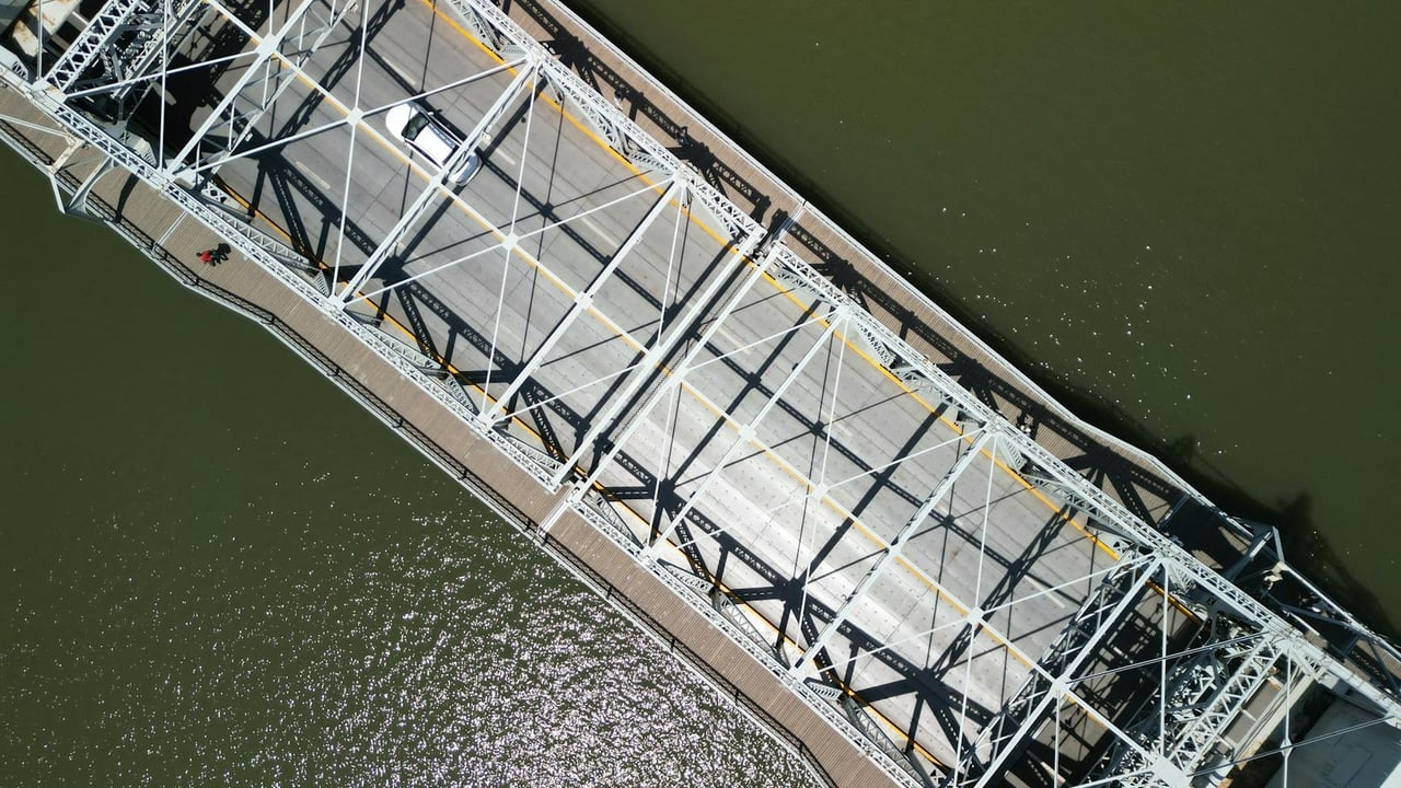Drone shot of a steel bridge over a river in Tianjin, China, showcasing urban infrastructure.