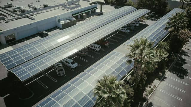 Aerial view of a parking lot with solar panel canopies, showcasing clean energy usage.