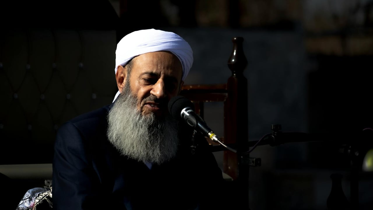 A religious leader speaks passionately during an outdoor Islamic ceremony.