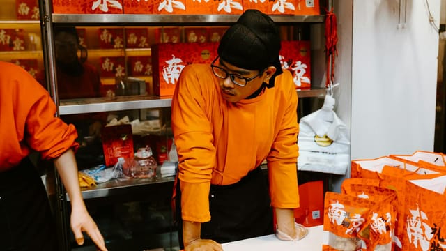 Engaging scene of a street vendor in vibrant Nanjing market, showcasing Chinese culture.