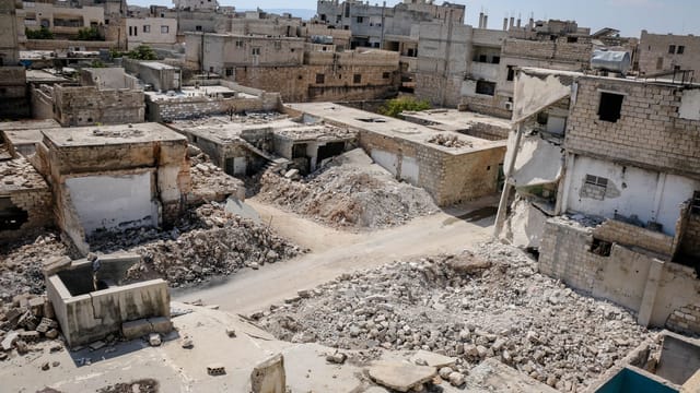 Aerial view of war-torn buildings and rubble in Idlib, Syria, highlighting urban destruction.