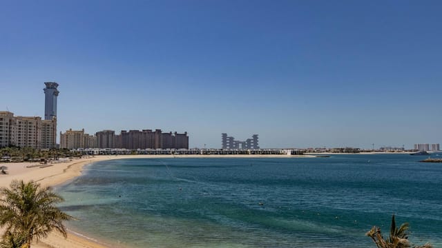 Beautiful beach view at Palm Jumeirah, Dubai with modern skyline and clear blue sea.