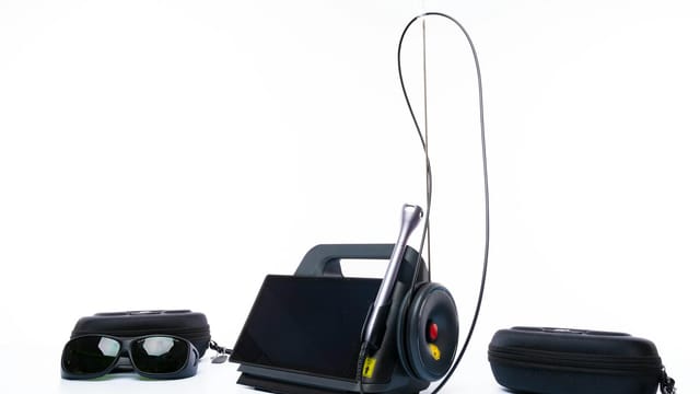 Laser equipment with accessories including goggles and carrying cases on a white background.