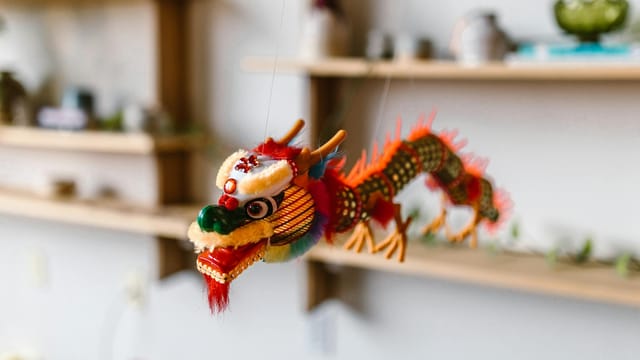 Vibrant Chinese dragon hanging as festive decor indoors, symbolizing celebration.