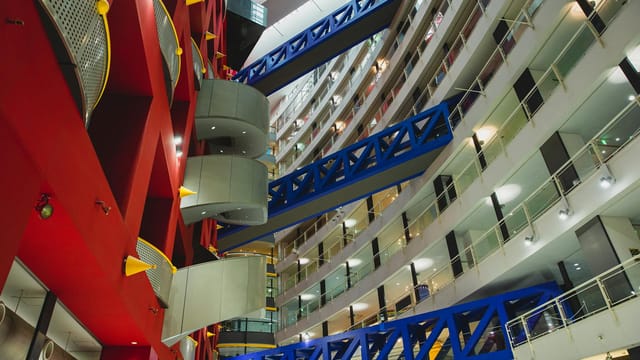 Dynamic low-angle view of a modern, multistory shopping mall interior with vibrant colors and geometric design.